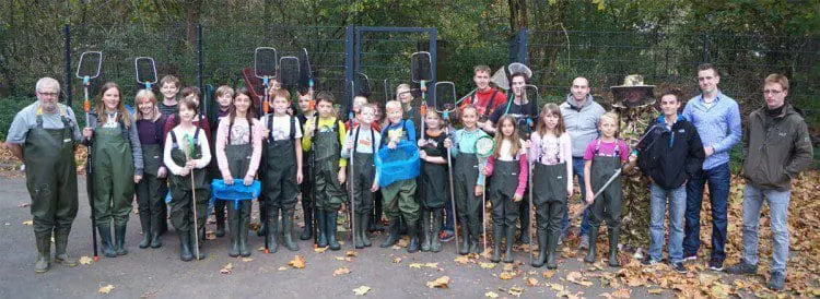 Mitglieder der Teich- und Imker-AG vor dem eingezäunten Gelände des Schulbiotops